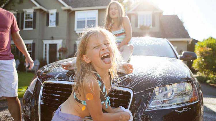 A family is washing their recently refinanced car at home.