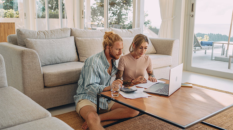 Couple looking at a computer discussing how to pay their mortgage.