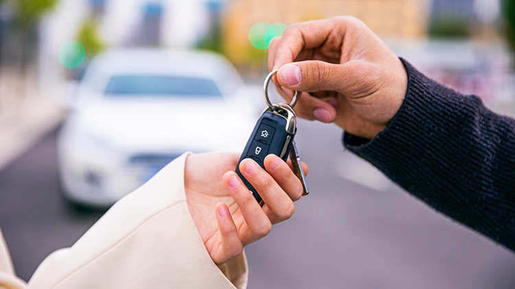 Man passing car keys to a woman.