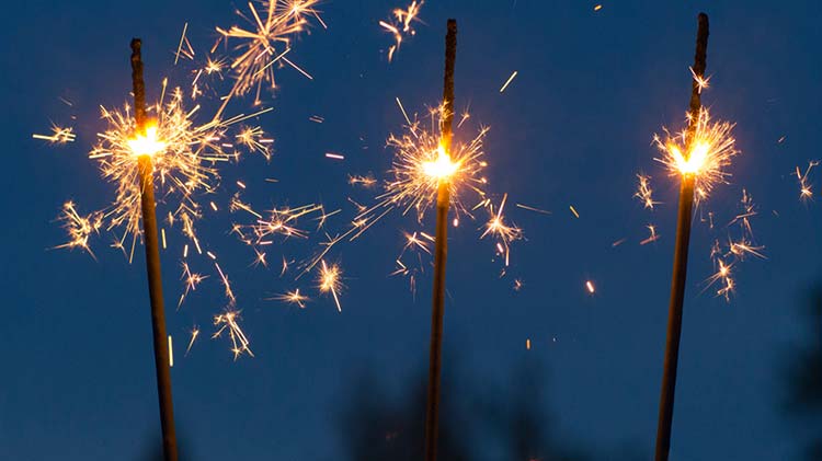 Sparklers burning against a night sky.