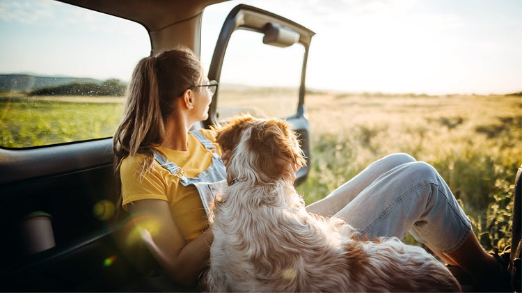 A young woman traveling with a dog.