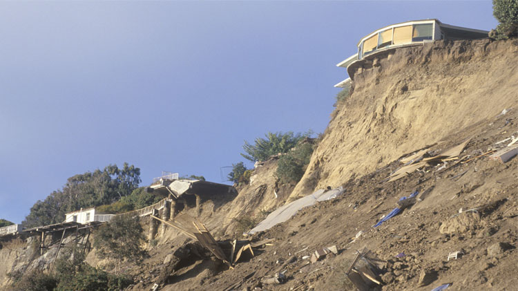 Earthquake damage to homes on a high ridge.