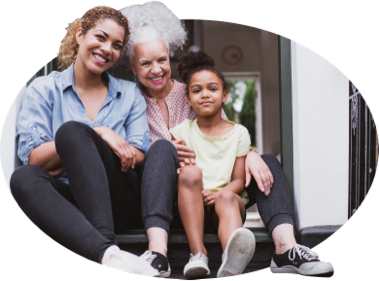 A grandmother, mother, and daughter sitting on a front porch.