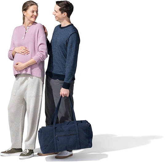 Pregnant woman and husband carrying a travel bag