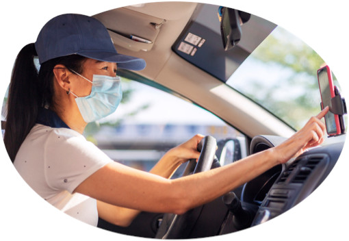 A masked and ballcapped woman taps for directions